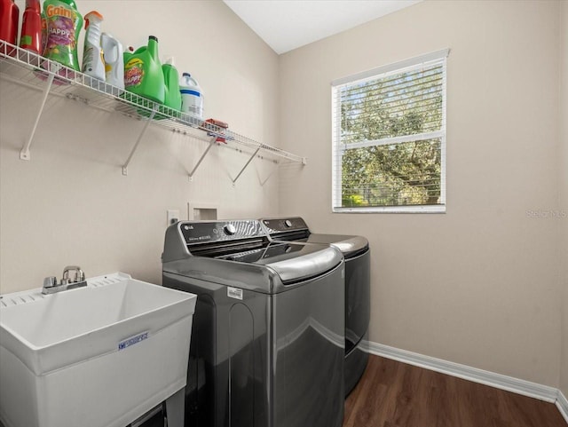 laundry room with sink, independent washer and dryer, and dark wood-type flooring