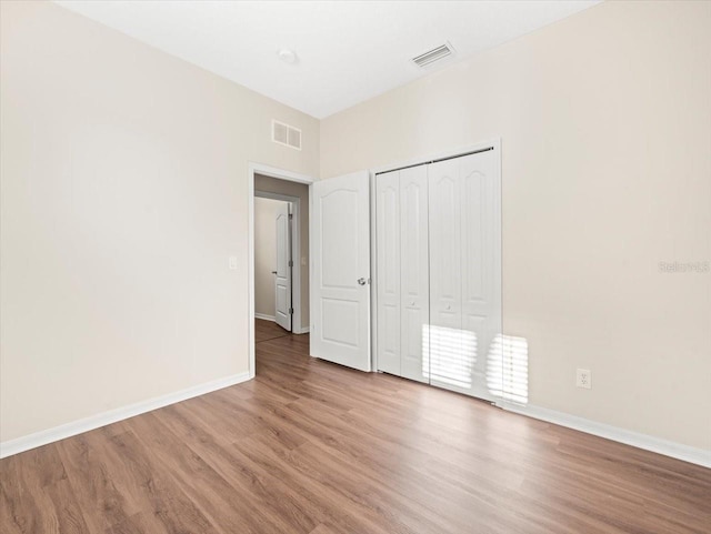 unfurnished bedroom featuring wood-type flooring and a closet