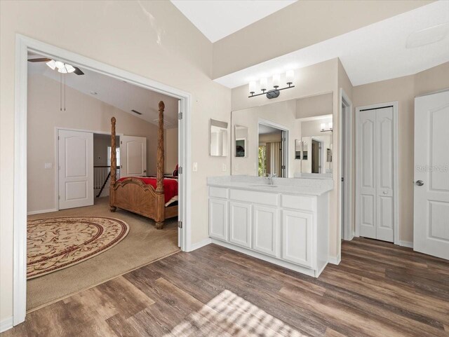 bathroom with vanity, hardwood / wood-style flooring, lofted ceiling, and ceiling fan