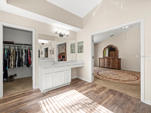 bathroom with vanity, lofted ceiling, and hardwood / wood-style flooring