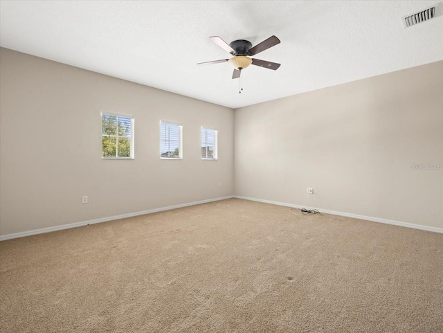 carpeted spare room with ceiling fan