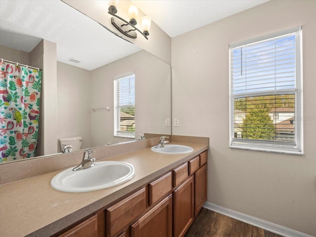 bathroom with vanity, toilet, and hardwood / wood-style floors