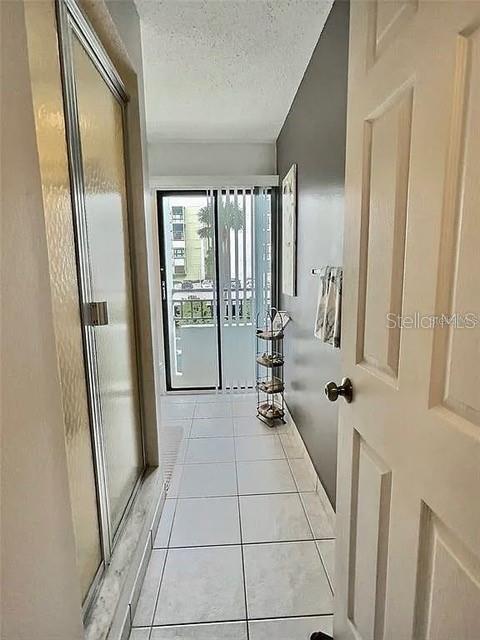 hall with light tile patterned floors and a textured ceiling