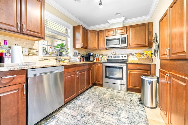 kitchen with light stone counters, ornamental molding, stainless steel appliances, and sink