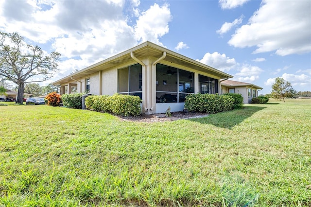 view of side of property with a yard and a sunroom