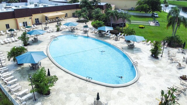 view of swimming pool with a lawn and a water view