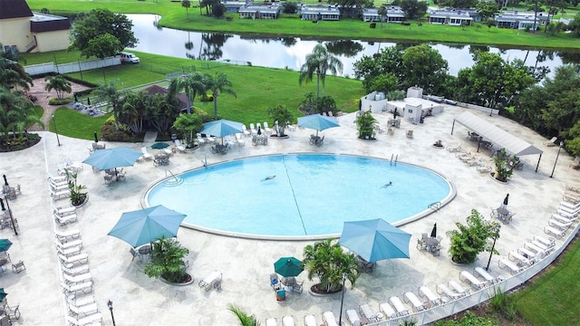 view of pool with a water view, a yard, and a patio area