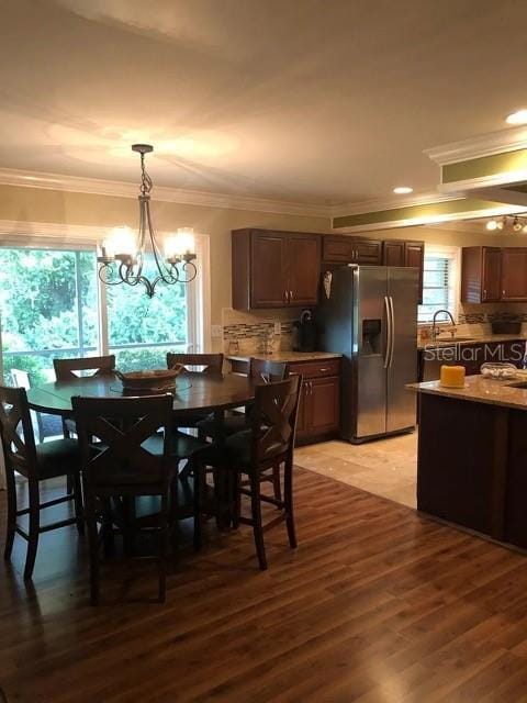 dining room with crown molding, light wood-style floors, a chandelier, and recessed lighting