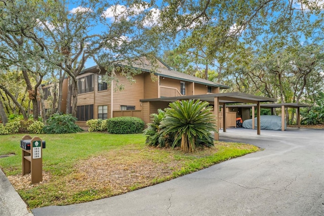 view of front of house featuring a carport and a front lawn