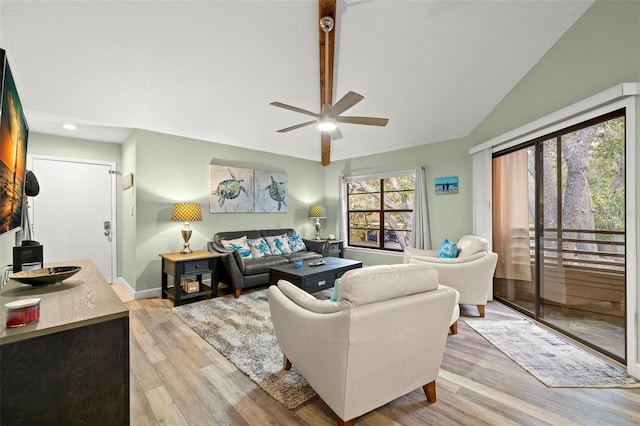 living room featuring ceiling fan, light hardwood / wood-style flooring, and vaulted ceiling