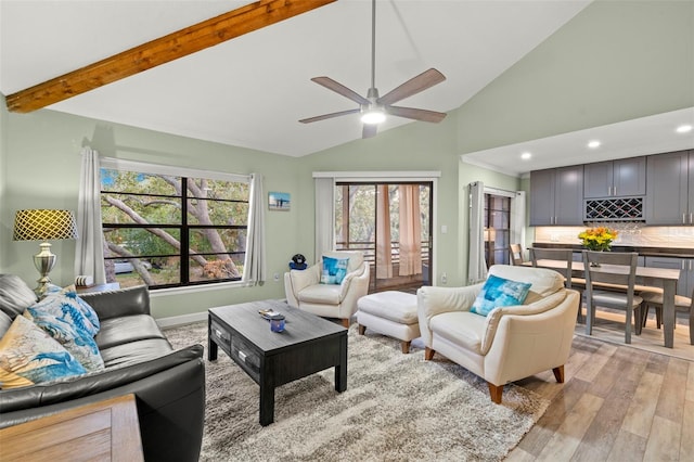 living room featuring lofted ceiling with beams, ceiling fan, and light hardwood / wood-style flooring