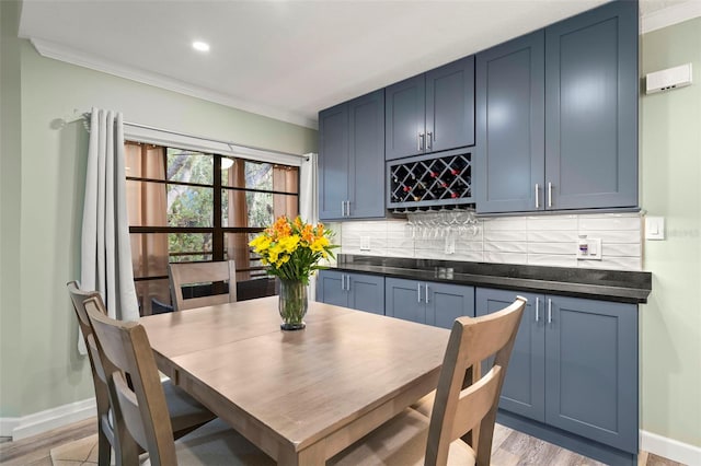 dining room with light hardwood / wood-style floors and crown molding