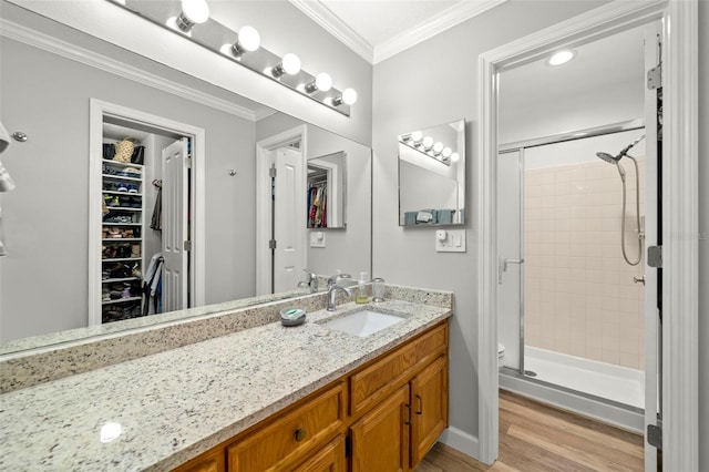 bathroom featuring wood-type flooring, vanity, an enclosed shower, and crown molding