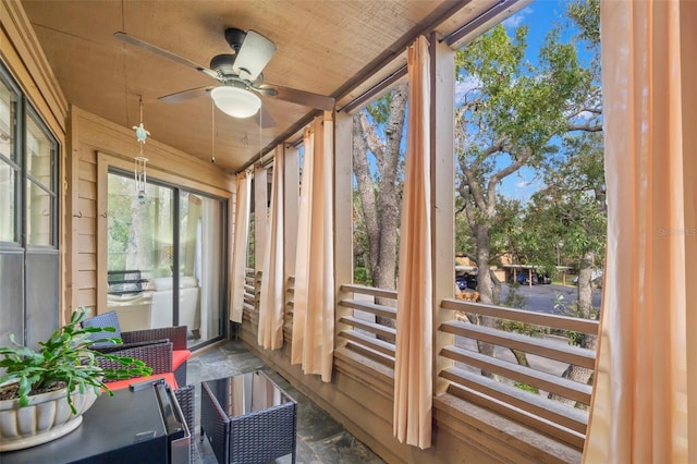 sunroom / solarium featuring ceiling fan and wood ceiling