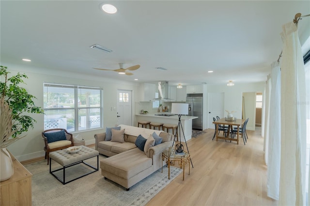 living room featuring ceiling fan and light hardwood / wood-style flooring