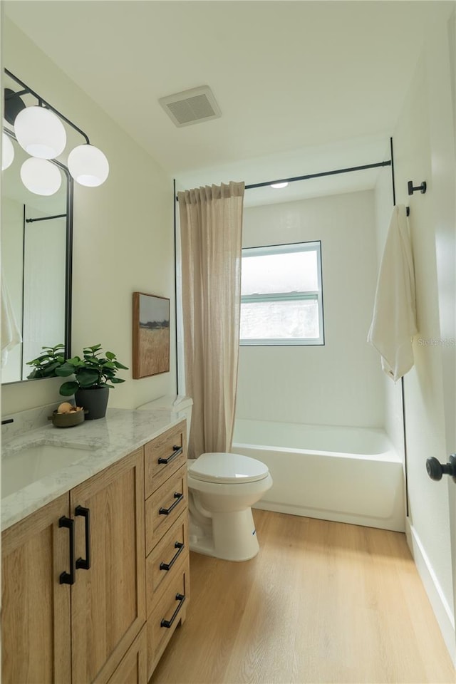 full bathroom featuring toilet, shower / tub combo with curtain, vanity, and wood-type flooring