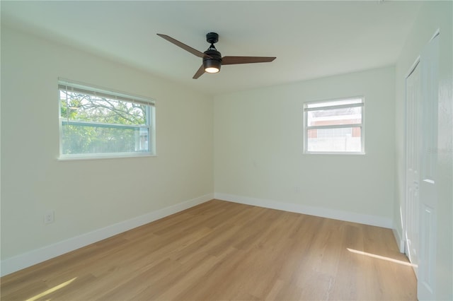 empty room featuring ceiling fan, light hardwood / wood-style floors, and plenty of natural light