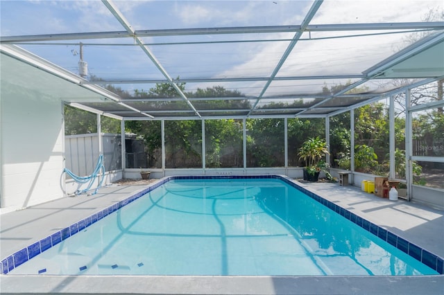 view of swimming pool with a patio and glass enclosure