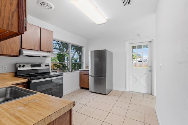 kitchen featuring light tile patterned floors, a healthy amount of sunlight, and stainless steel appliances