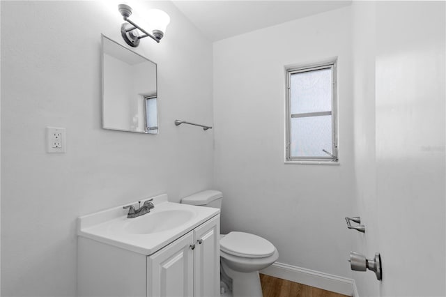 bathroom with hardwood / wood-style flooring, vanity, and toilet