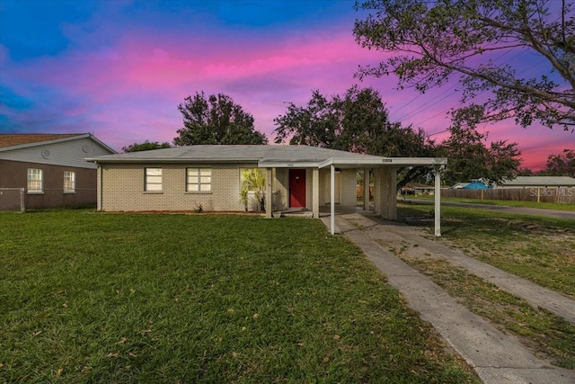 view of front of property with a yard and a carport