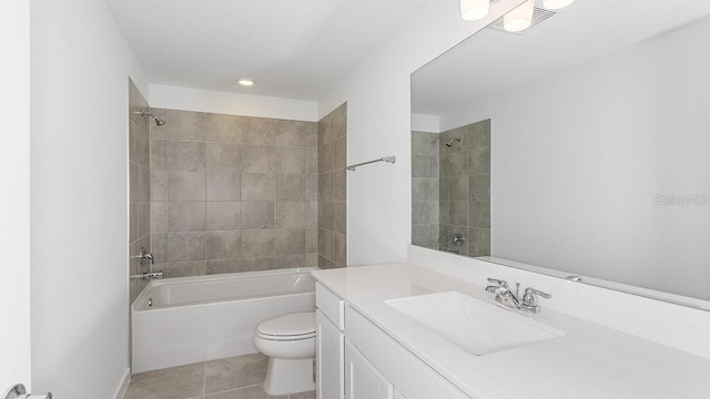 full bathroom featuring tile patterned flooring, tiled shower / bath, vanity, and toilet