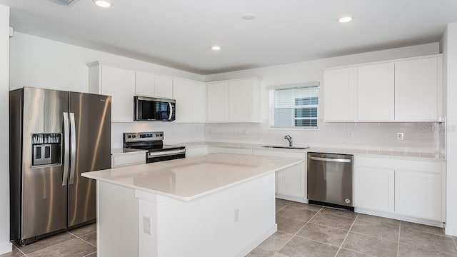 kitchen with white cabinetry, sink, a kitchen island, and appliances with stainless steel finishes