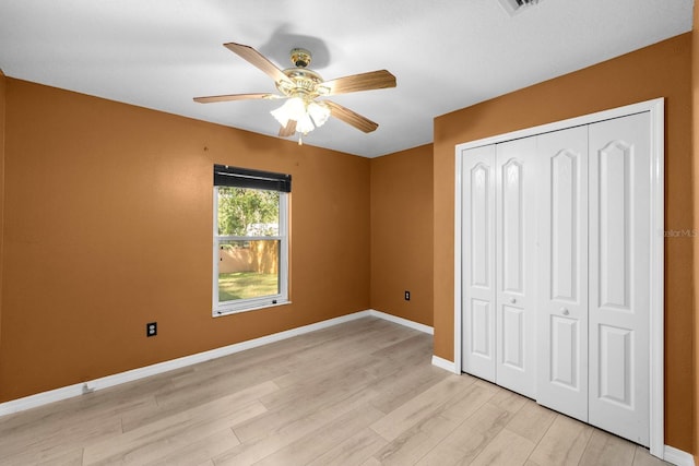 unfurnished bedroom featuring ceiling fan, light wood-type flooring, and a closet