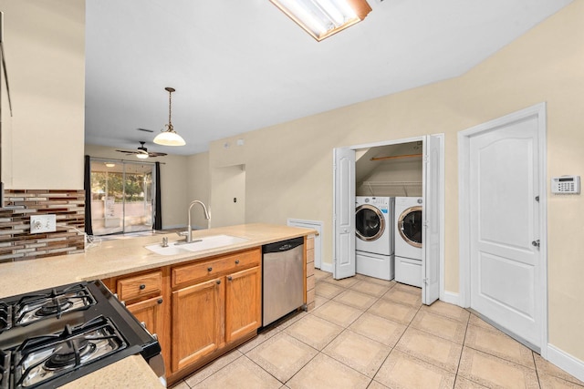 kitchen featuring separate washer and dryer, sink, black range with gas stovetop, hanging light fixtures, and stainless steel dishwasher