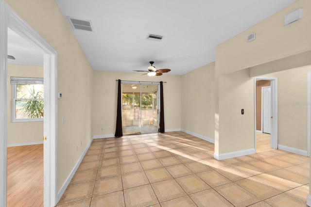 spare room with light tile patterned floors, plenty of natural light, and ceiling fan