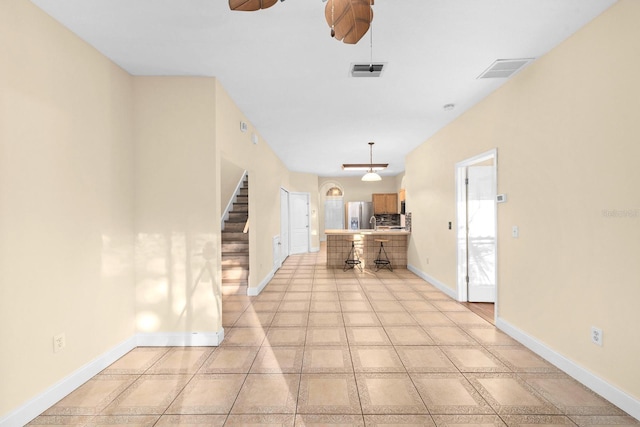 unfurnished living room featuring light tile patterned floors and ceiling fan