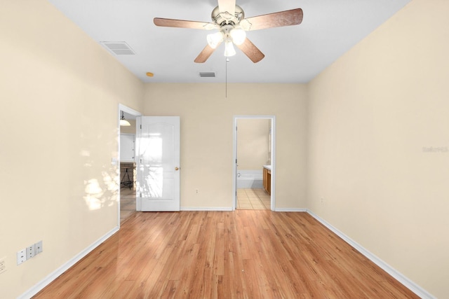 unfurnished bedroom with ensuite bath, ceiling fan, and light wood-type flooring