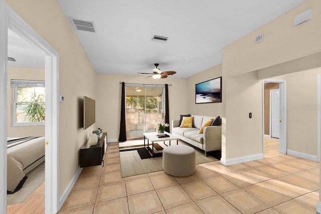 living room featuring a healthy amount of sunlight, light tile patterned floors, and ceiling fan