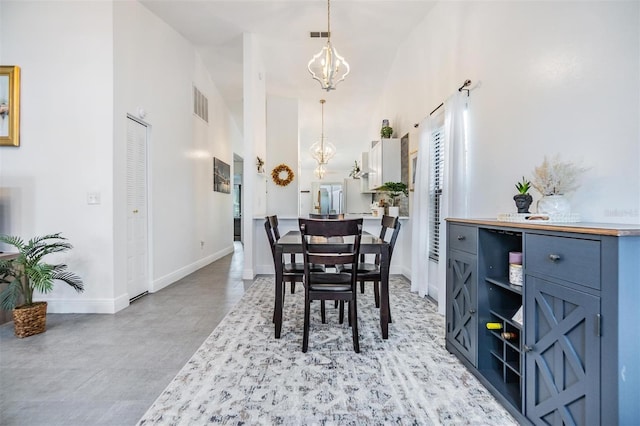 dining room featuring a chandelier and high vaulted ceiling