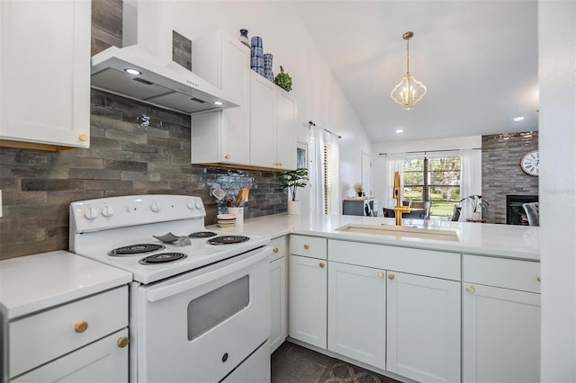 kitchen featuring vaulted ceiling, white cabinets, kitchen peninsula, wall chimney range hood, and electric range