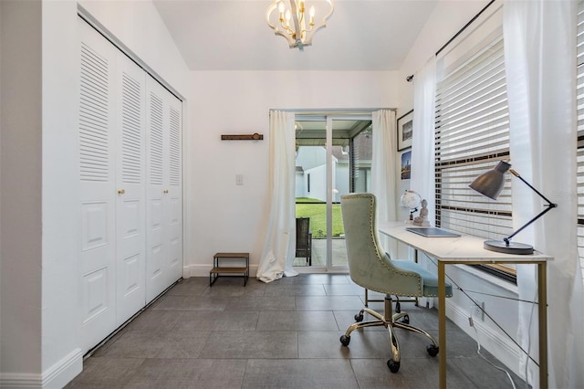 office area with dark tile patterned flooring and an inviting chandelier