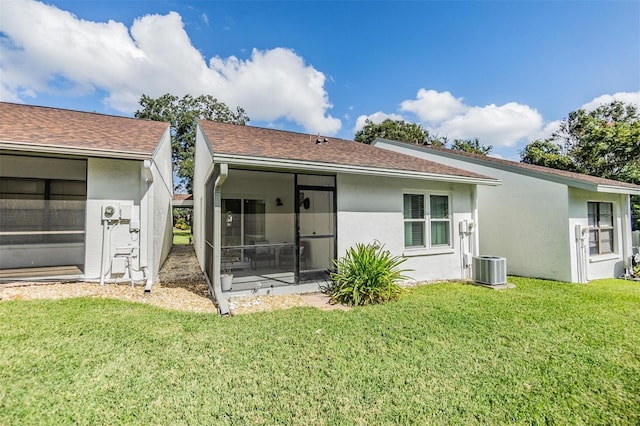 rear view of property featuring a sunroom and a yard