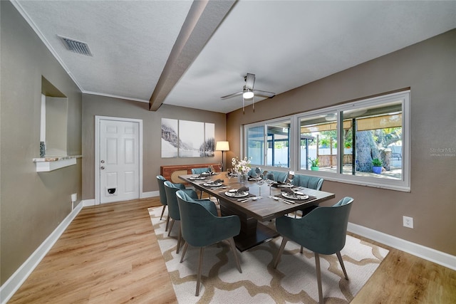 dining area with ceiling fan, beamed ceiling, and light hardwood / wood-style flooring