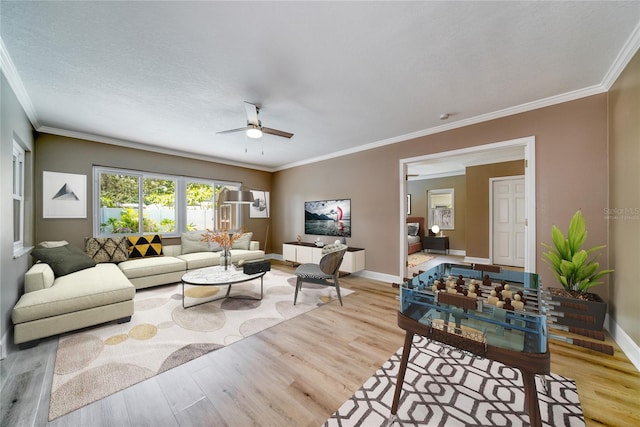 living room with crown molding, a textured ceiling, light wood-type flooring, and ceiling fan