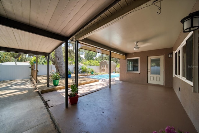 view of patio / terrace with a storage shed, a fenced in pool, and ceiling fan