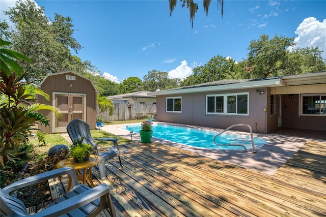 view of pool featuring a storage shed and a deck