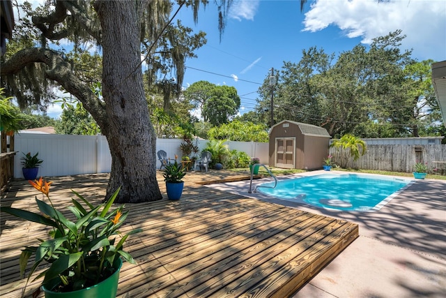 view of pool with a wooden deck and a storage shed