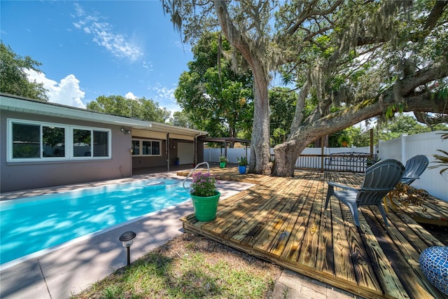 view of pool featuring a patio and a wooden deck