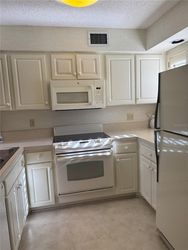 4774 Fox Hunt Drive C115 &C113, Wesley Chapel, FL 33543 - kitchen with white appliances, light countertops, light tile patterned flooring, a textured ceiling, and a sink