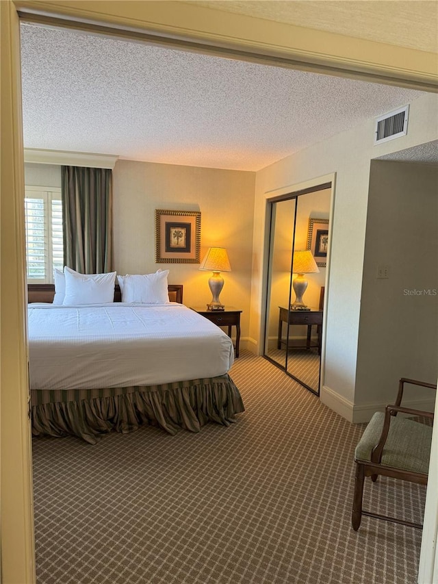 bedroom featuring a closet, carpet, and a textured ceiling