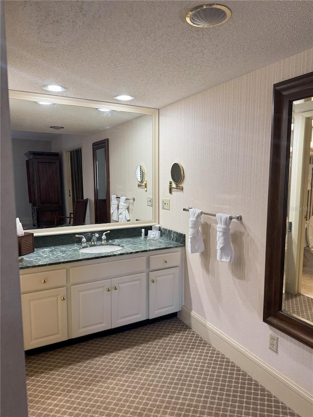 4774 Fox Hunt Drive C115 &C113, Wesley Chapel, FL 33543 - bathroom featuring a textured ceiling, baseboards, and vanity