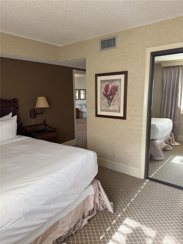 bedroom with a textured ceiling and carpet floors