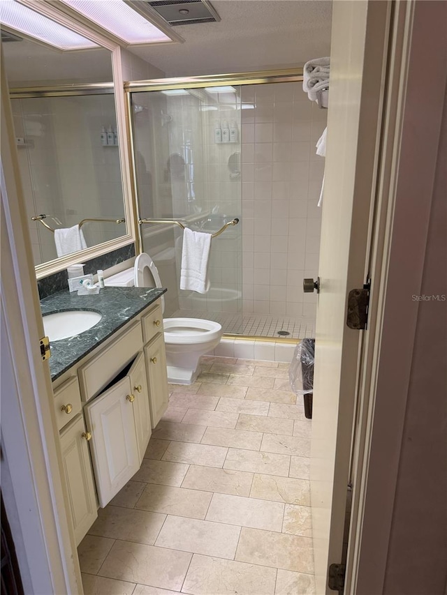 bathroom with vanity, tile patterned flooring, toilet, and an enclosed shower