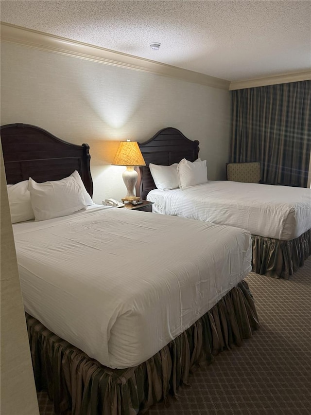 carpeted bedroom with crown molding and a textured ceiling