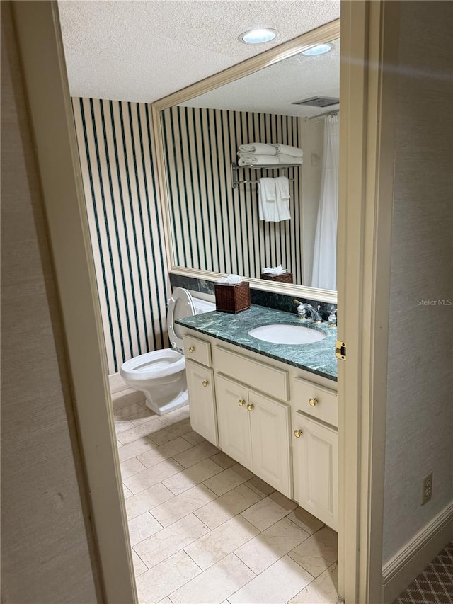 4774 Fox Hunt Drive C115 &C113, Wesley Chapel, FL 33543 - bathroom featuring a textured ceiling, wallpapered walls, vanity, toilet, and baseboards